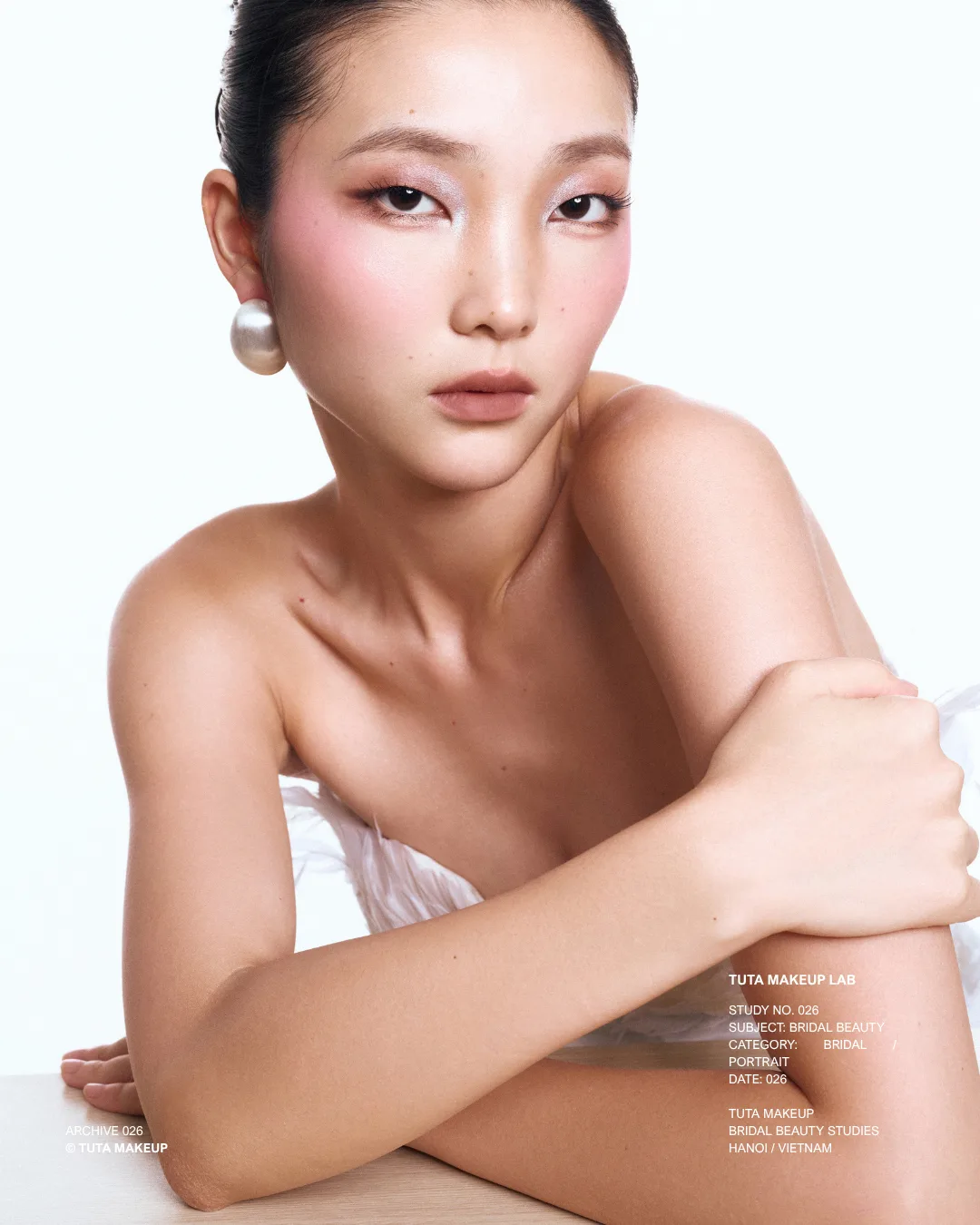 Refined bridal beauty by TUTA with luminous skin and pearl earrings